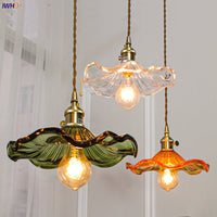 Drei bunte Glas-Pendelleuchten mit Edison-Glühbirnen, Vintage-Stil, Wohnzimmerbeleuchtung.