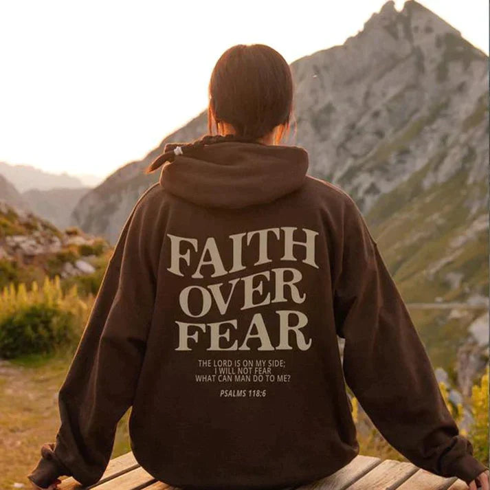 Unisex Hoodie mit "Faith Over Fear" Aufdruck, braun, Baumwolle, Psalmen 118:6, Berge im Hintergrund.