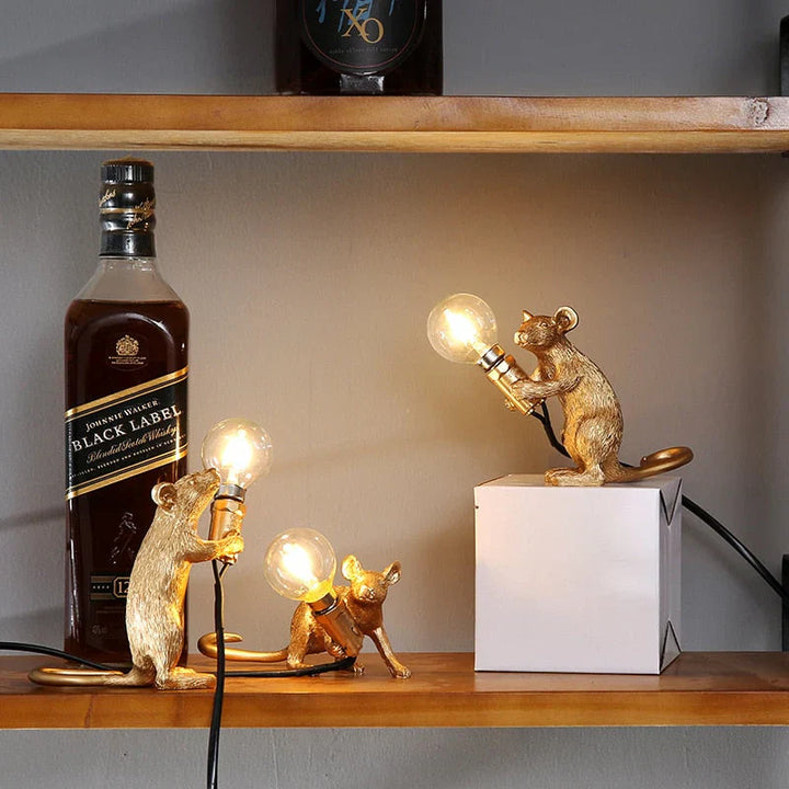 Goldene Maus-Lampen mit Glühbirnen auf Regal neben Whiskyflasche, dekorative Tischleuchten.