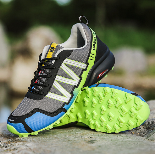 Grauer und grüner Trailrunning-Schuh mit rutschfester Sohle, ideal für Outdoor-Aktivitäten.