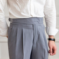 Mann in weißem Hemd und grauer Anzughose mit Gürtel, Businessmode, elegante Herrenbekleidung.
