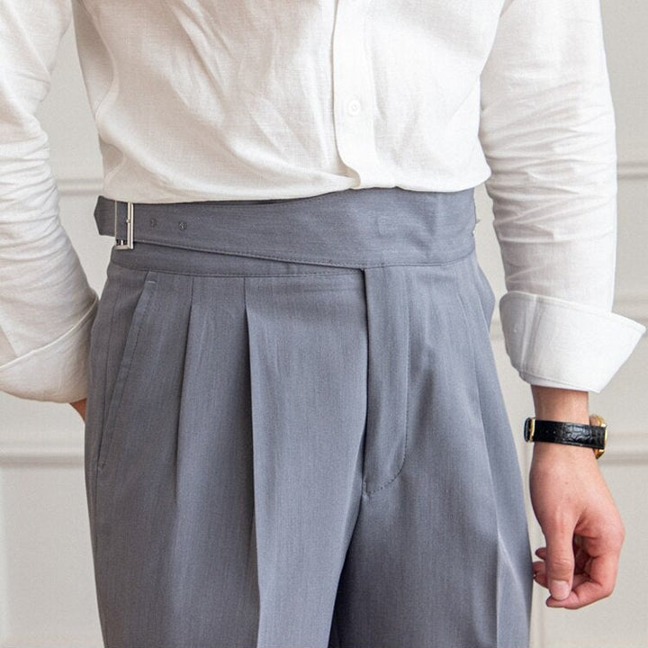 Mann in weißem Hemd und grauer Anzughose mit Gürtel, Businessmode, elegante Herrenbekleidung.