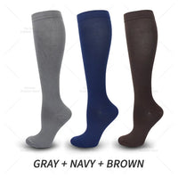Drei Paar Kniestrümpfe in Grau, Marineblau und Braun, ideal für Outdoor-Aktivitäten.