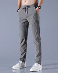 Graue Herren-Sporthose, elastisch, atmungsaktiv, mit Kordelzug, ideal für Fitness und Freizeit.