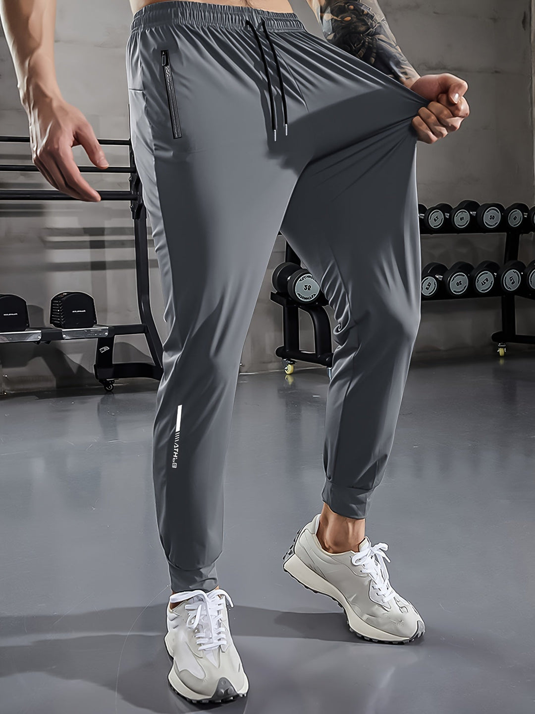 Graue Herren-Trainingshose, elastisch, mit Reißverschlusstaschen, im Fitnessstudio.