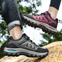 Graue und pinke Wanderschuhe, robust, rutschfest, ideal für Outdoor-Aktivitäten.
