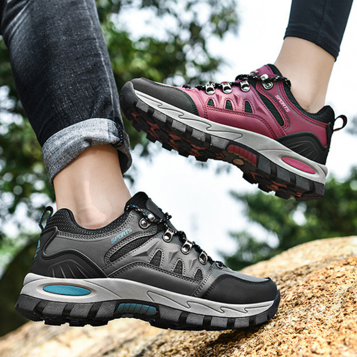 Graue und pinke Wanderschuhe, robust, rutschfest, ideal für Outdoor-Aktivitäten.