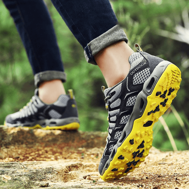 Graue Outdoor-Wanderschuhe mit gelber Sohle, atmungsaktiv, ideal für Trekking und Abenteuer.