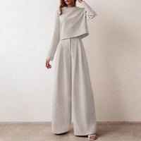 Frau in grauem Anzug, weites Design, eleganter Look, modische Damenbekleidung.