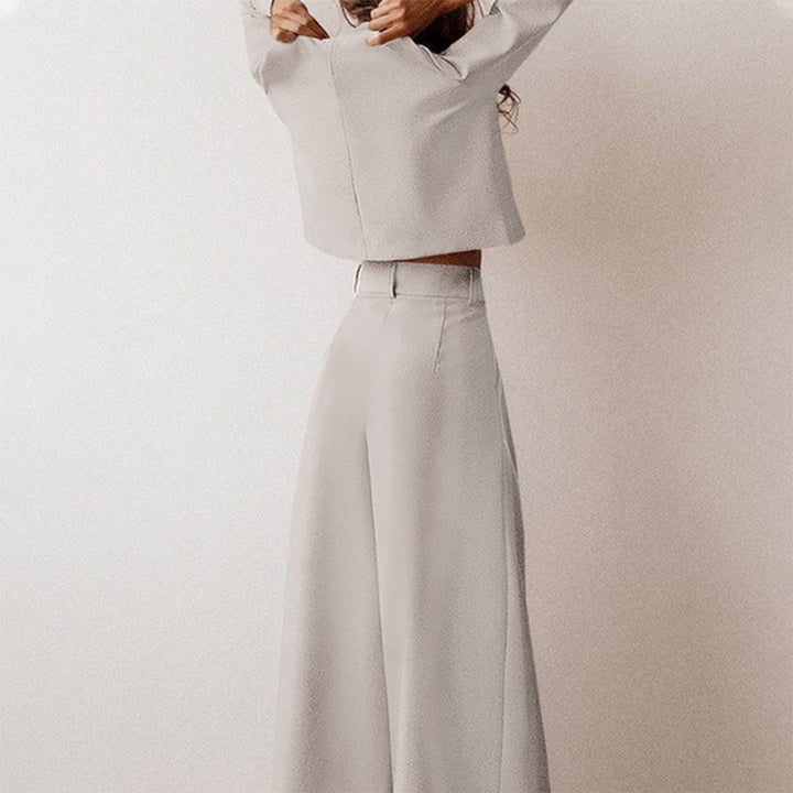 Grauer Damenanzug, weites Bein, elegantes Design, minimalistischer Stil, hochwertige Mode.