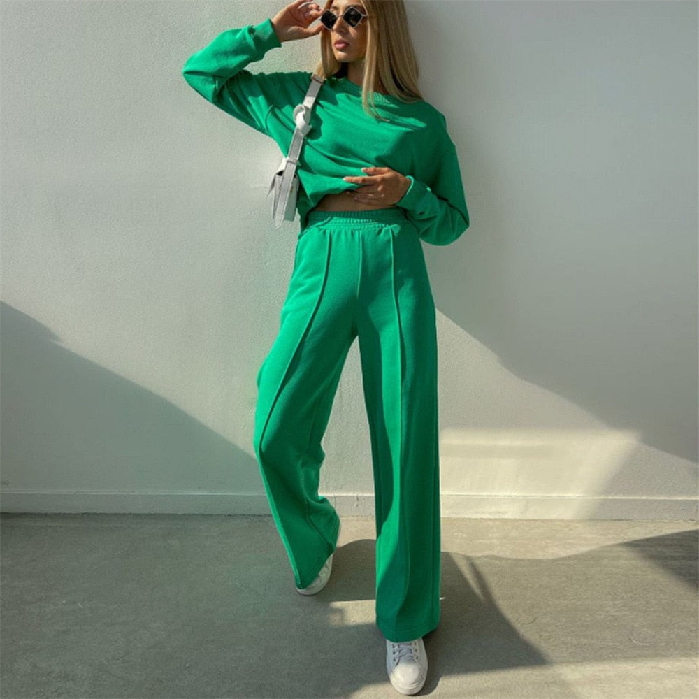 Frau in grünem Jogginganzug, Sonnenbrille, weiße Sneakers, modisch, lässig, Streetwear.