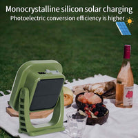 Grünes monokristallines Solarladegerät auf Picknickdecke mit Essen und Getränken.