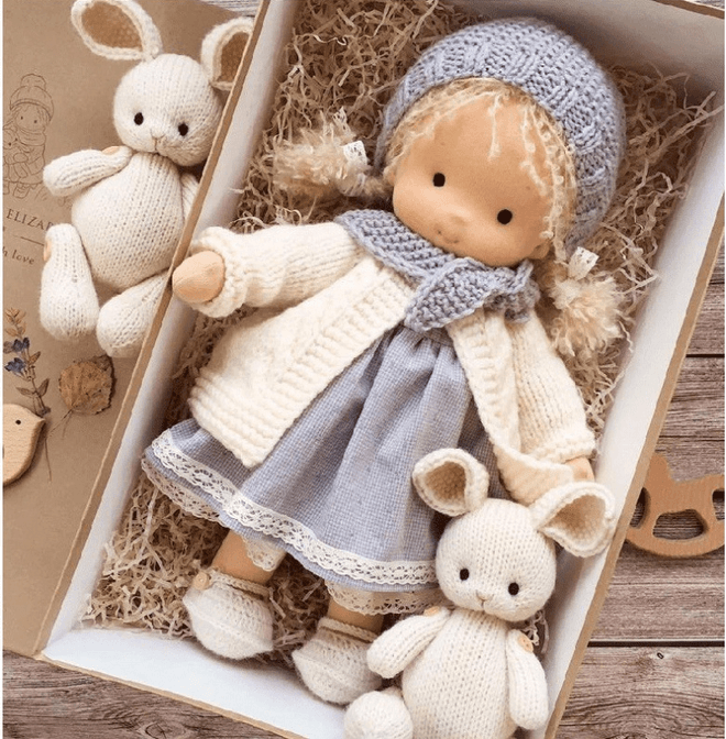 Handgemachte Waldorf-Puppe in blauer Kleidung mit gestrickten Hasen, Geschenkbox.