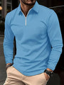 Mann in hellblauem Langarm-Poloshirt mit Reißverschluss, beige Hose, Armbanduhr.