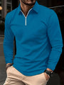 Mann in blauem Langarmshirt mit Reißverschluss, beige Hose, Armbanduhr, modisch, urban.