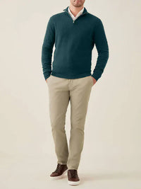 Mann trägt grünen Kaschmir-Pullover mit Reißverschluss, beige Hose, braune Schuhe.