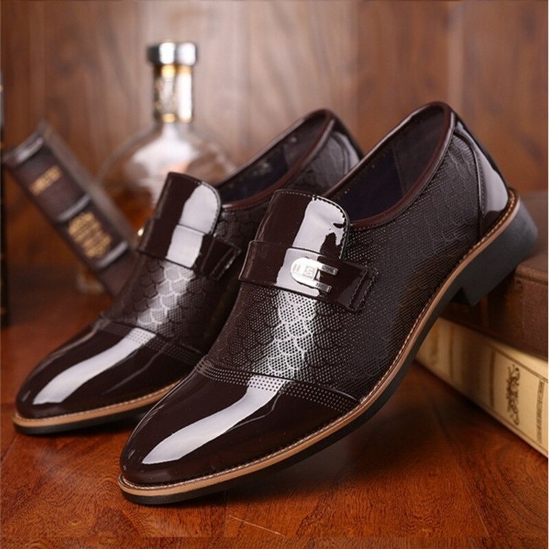 Braune Herren-Lederslipper, glänzend, mit Schnalle, elegantes Design, auf Holzboden.