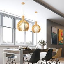 Moderne Esszimmer mit hölzernen Pendelleuchten, Esstisch, schwarzen Stühlen, Fenster.