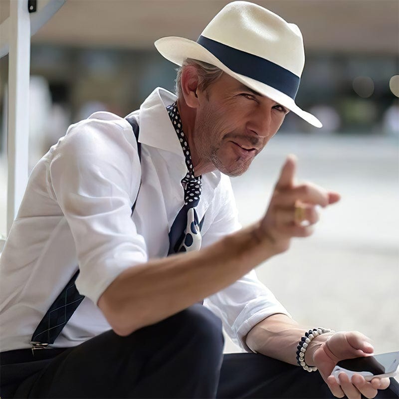 Mann mit weißem Panama-Hut, weißem Hemd und Smartphone, stilvoller Look, Sommermode.