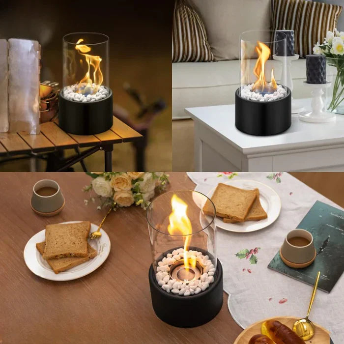Tragbarer Tischkamin mit Glaszylinder, schwarzem Sockel und weißen Steinen, ideal für Innenräume.