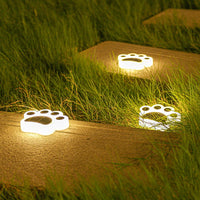 Leuchtende Pfotenabdruck-Solarleuchten im Garten, energiesparend, dekorativ, wetterfest.