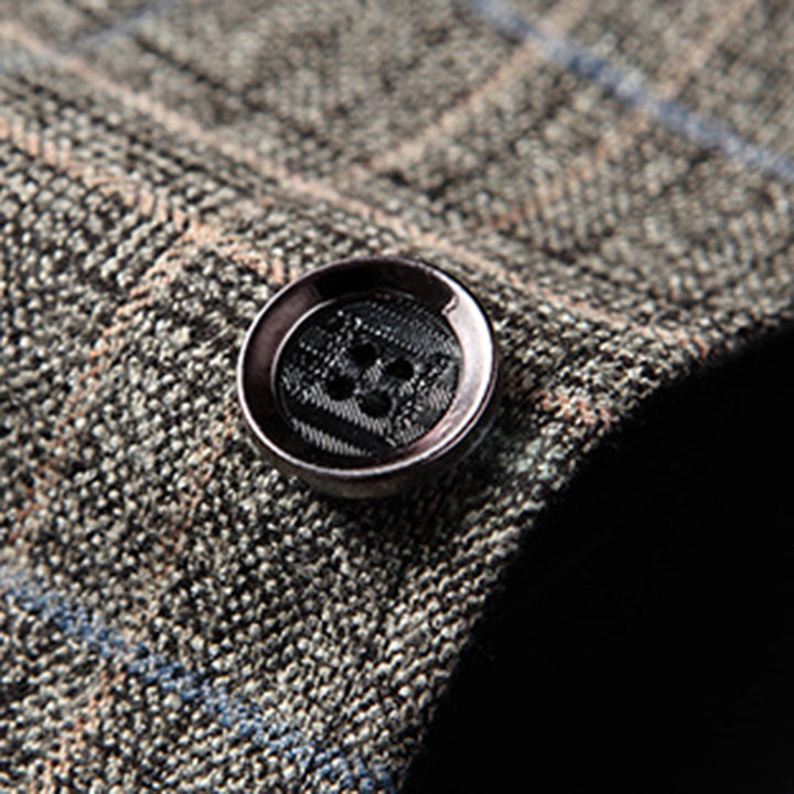 Nahaufnahme eines karierten Wollstoffs mit Knopf, braun-grau, Textilmode-Detail.
