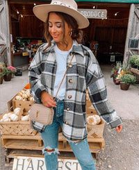 Frau in kariertem Mantel und Hut vor Bauernmarkt, Herbstmode, lässiger Stil, Jeans, Handtasche.