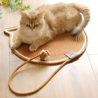 Katzenbett aus geflochtenem Seil, rund, beige, mit Spielzeug, auf Holzboden, gemütlich.