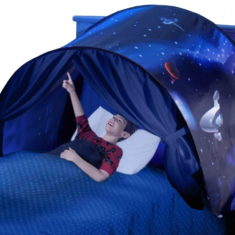 Junge in blauem Betthimmel mit Weltraummotiv, zeigt nach oben, Kinderzimmer-Dekoration.