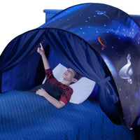 Junge in blauem Betthimmel mit Weltraummotiv, zeigt nach oben, Kinderzimmer-Dekoration.
