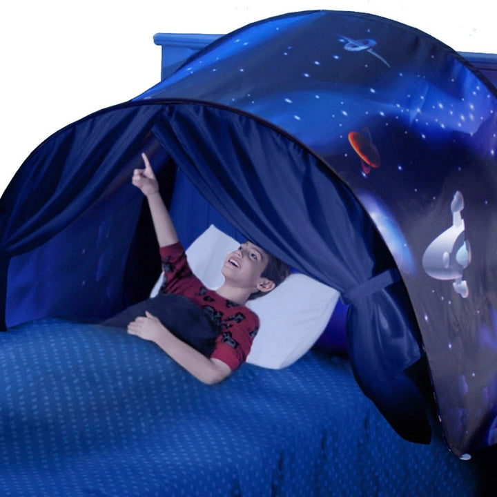 Junge in blauem Betthimmel mit Weltraummotiv, zeigt nach oben, Kinderzimmer-Dekoration.