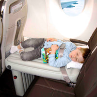 Kind auf Flyaway Kids Bed im Flugzeug, liest Buch, bequemes Reisen, Kinderbett, Flugzeugzubehör.