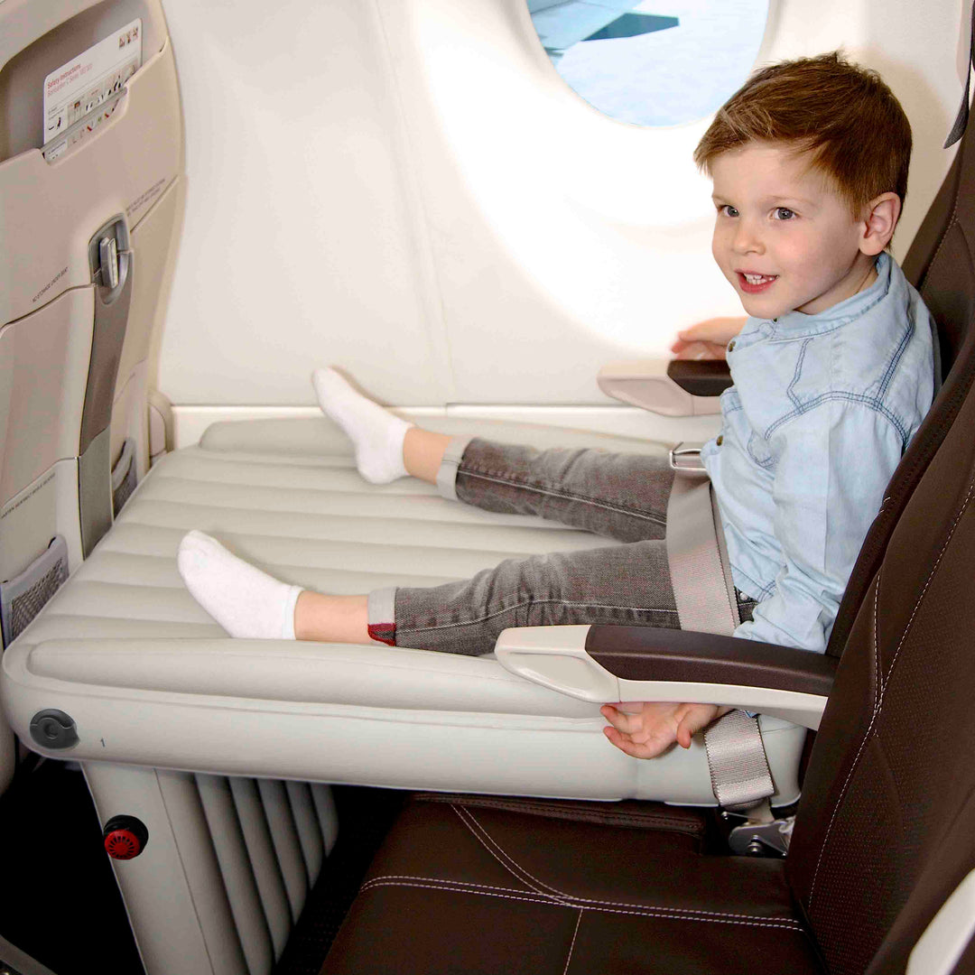 Junge sitzt auf Flyaway Kids Bed im Flugzeug, blaues Hemd, Reisesitz, Kindersitz, Komfort.