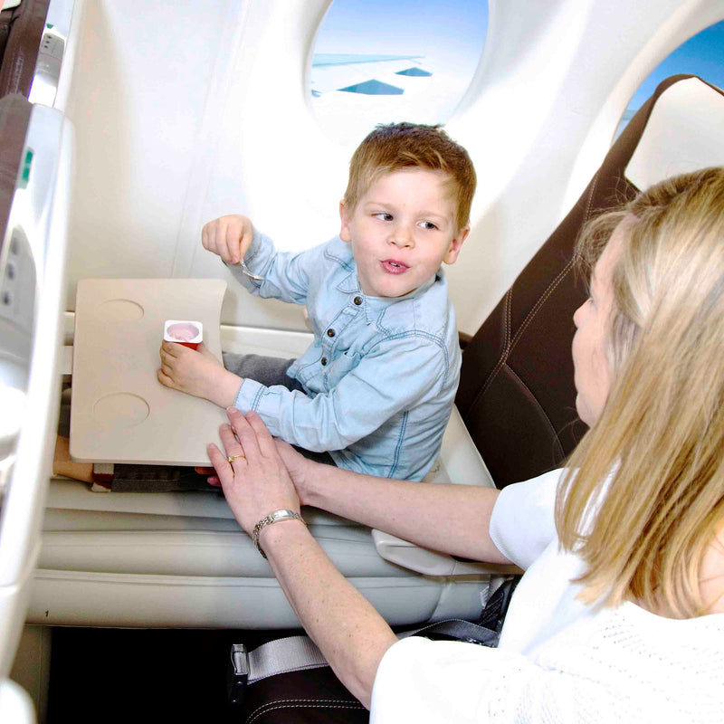 Junge isst auf Flyaway Kids Bed im Flugzeug, Kindersitz, Reisen, Komfort, Flugzeugkabine.