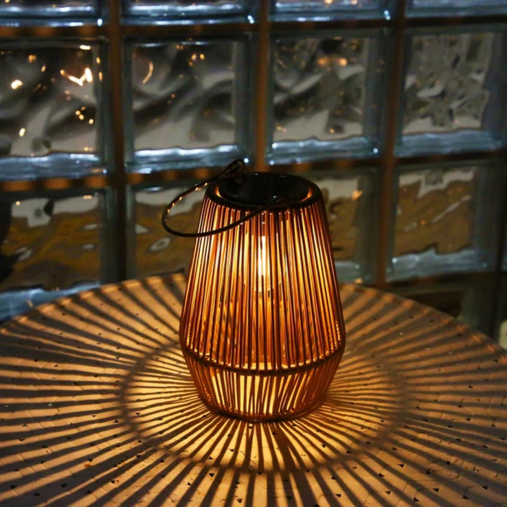 Rattan-Laterne mit Kerze, warmes Licht, dekorative Beleuchtung, Tischdekoration, Nachtambiente.
