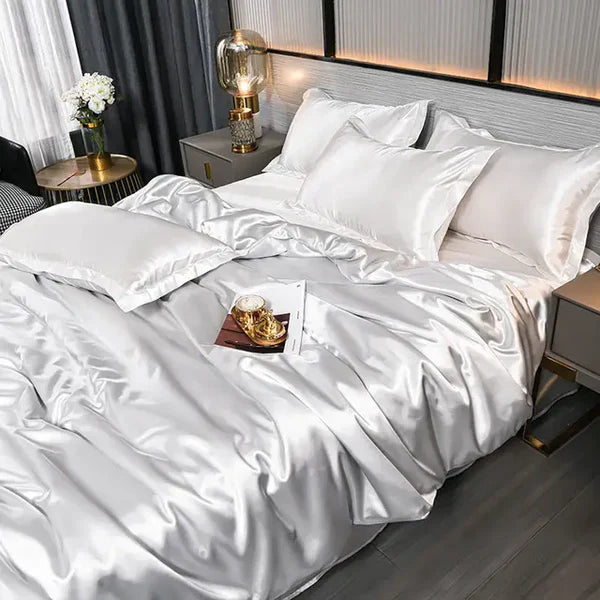 Luxuriöses weißes Seidensatin-Bettwäsche-Set mit Kissen, elegantem Schlafzimmerdekor.