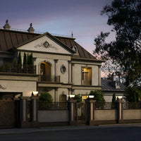 Luxusvilla bei Sonnenuntergang, klassischer Baustil, elegante Fassade, hochwertige Materialien.