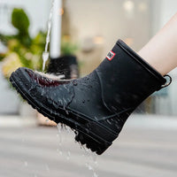 Schwarzer wasserdichter Gummistiefel, spritzwassergeschützt, rutschfeste Sohle.