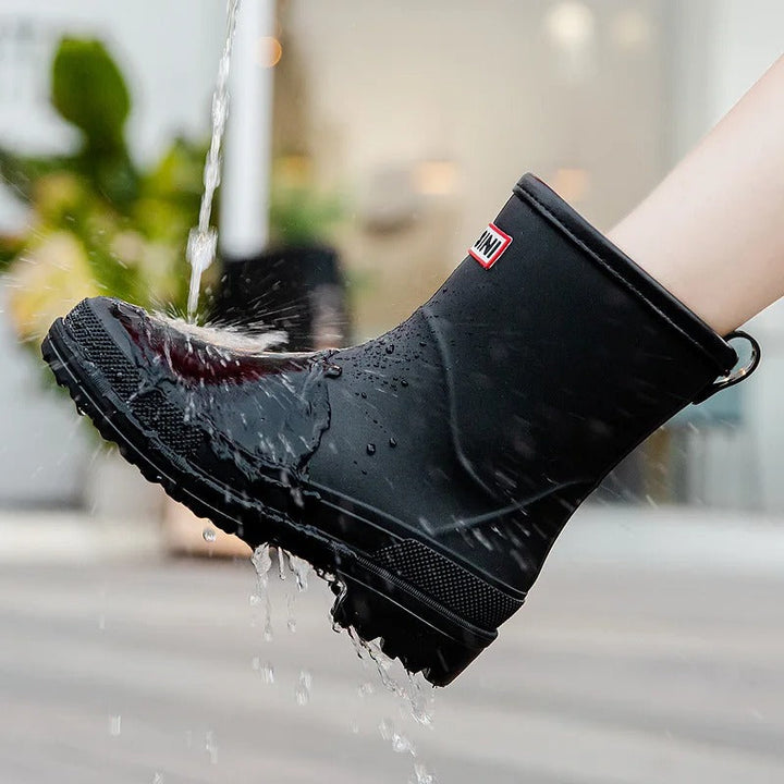 Schwarzer wasserdichter Gummistiefel, spritzwassergeschützt, rutschfeste Sohle.