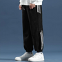 Schwarze Herren-Jogginghose mit weißen Streifen, warm, bequem, ideal für Winterkleidung.