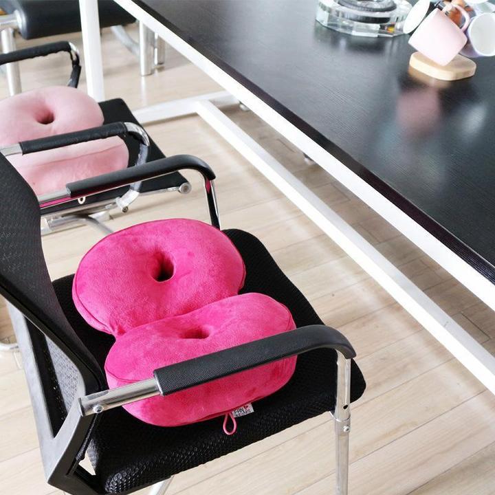 Rosa ergonomisches Sitzkissen auf schwarzem Bürostuhl, ideal für Komfort und Haltung im Büro.