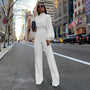 Frau in weißem Jumpsuit mit Stehkragen auf Stadtstraße, modisch, elegant, urbaner Stil.