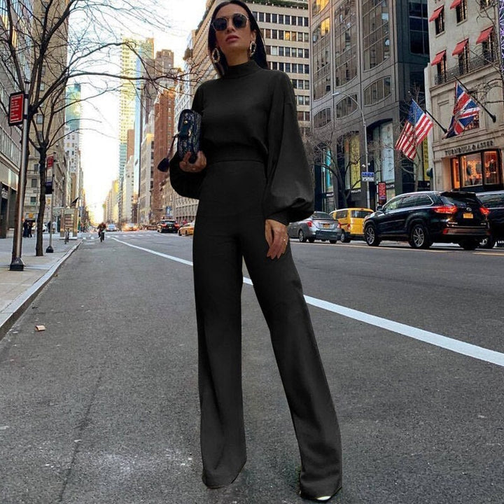 Frau in schwarzem Jumpsuit auf Stadtstraße, Mode, eleganter Look, urbane Kulisse.