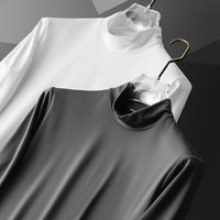Zwei Rollkragenpullover, weiß und grau, auf Kleiderbügeln, aus Baumwolle, minimalistisch.