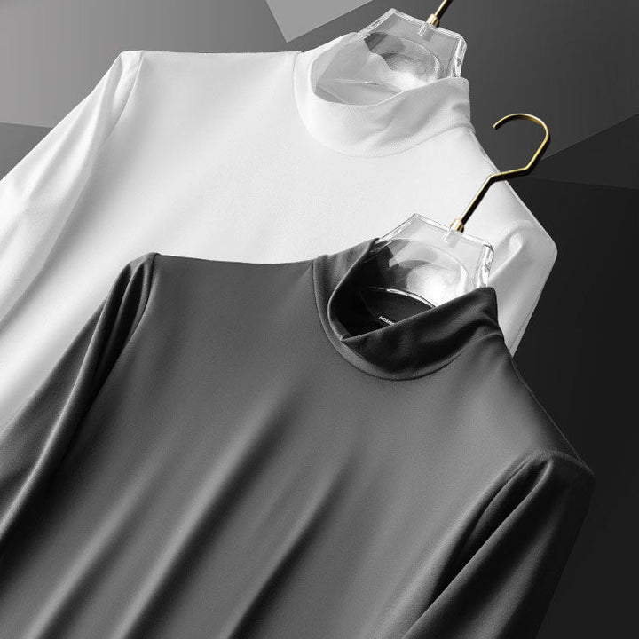 Zwei Rollkragenpullover, weiß und grau, auf Kleiderbügeln, aus Baumwolle, minimalistisch.