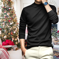 Mann in schwarzem Pullover vor Weihnachtsbaum, Wohnzimmer, festliche Dekoration, Armbanduhr.