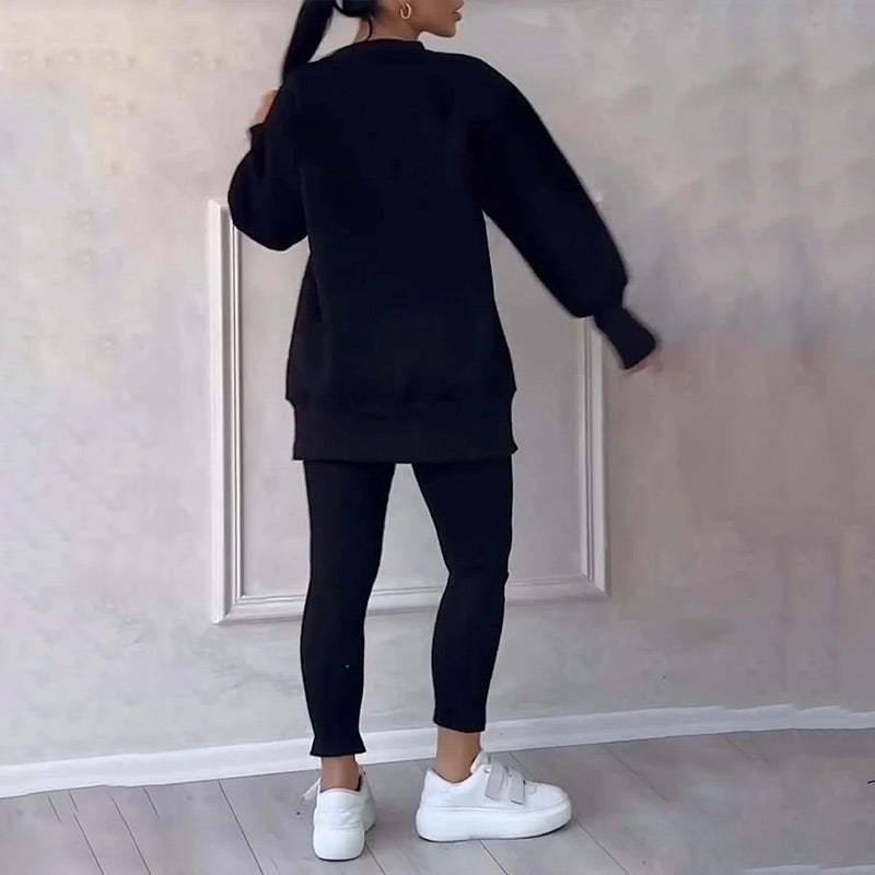 Frau in schwarzem Oversize-Pullover und Leggings, weiße Sneaker, moderne Freizeitmode.